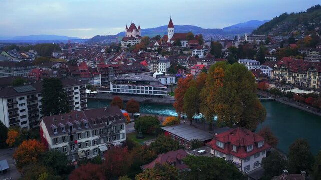 Flusswelle Aare River Schloss Thun sunrise sunset Thun Castle Thunersee Switzerland Schweiz Europe Autumn Fall aerial drone morning grey skies pedestrian walkway car Bernese Oberland forwards pan up