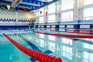 A large indoor swimming pool with swimming lanes highlighted by floats