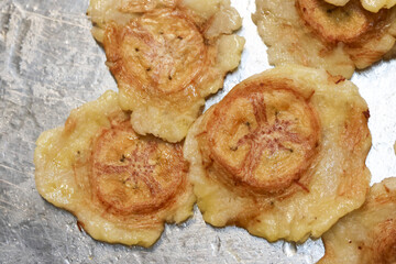 Crispy golden fried plantain tostones silver foil background look appetizing and savory, offering delicious authentic latin snack texture with salty flavor perfect for tasty caribbean appetizers © Core