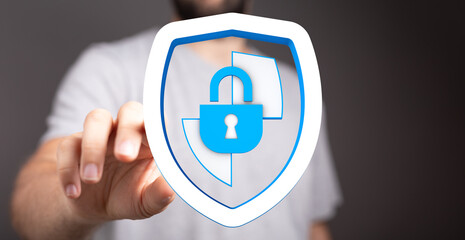 A person's hand interacting with a digital shield icon showcasing cybersecurity.  This image evokes a sense of protection, data safet