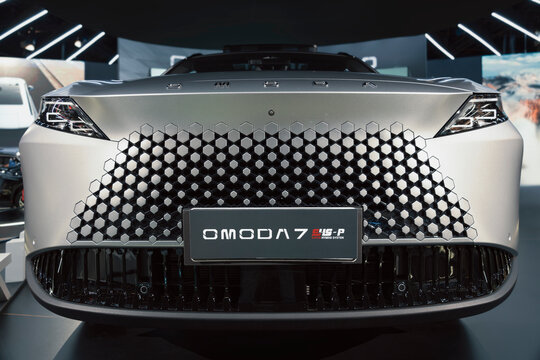 Front of the Chery Omoda 7, highlighting the three-dimensional hexagonal grille pattern and the E4G-P hybrid system on display.