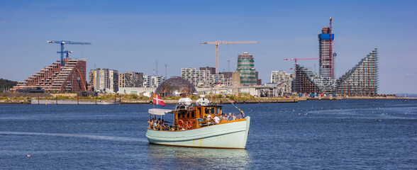 Panorama of a boat taking tourists on a tour in the harbor of Aarhus, Denmark