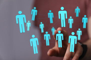 Hand touching network of people icons, representing the concepts of community, teamwork, and global...