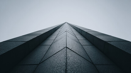 Low angle view of modern dark granite skyscraper exterior pointing towards the sky, abstract architecture background