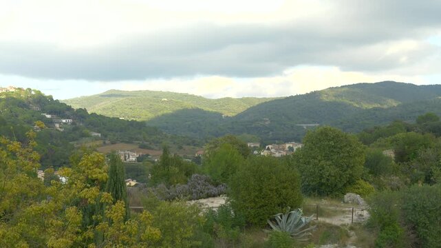 Gentle Light Touching Catalan Hills and Villages Under Cloudy Sky in Mediterranean Countryside