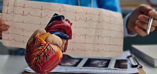 Doctor hold result of the cardiogram next to patient sitting