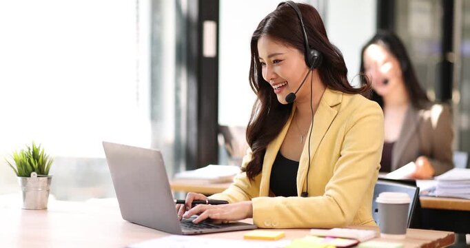 Asian female operator working laptop and call center agent in the office. Call center customer service. Customer crm and help or support.
