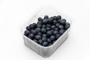 Fresh blueberries are in a transparent plastic package on a white background.