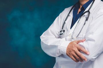 Doctor standing with crossed arms in medical uniform.
