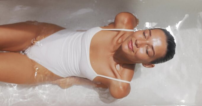 Beautiful Woman In White Swimsuit Relaxing In Warm Spa Bath For Wellness