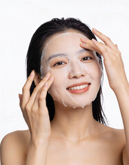 Portrait of young asian woman with facial mask on white background