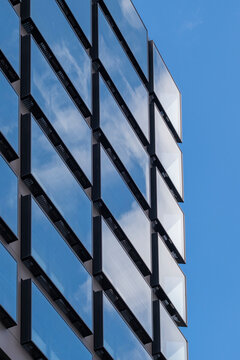 Modern architecture building facade with windows in grid under blue sky for urban office corporate modern exterior background and branding space