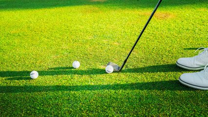 Golf player strikes ball on the green Golf Course in the daytime