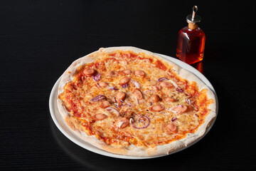 A plate of pizza with calamari and German sausage