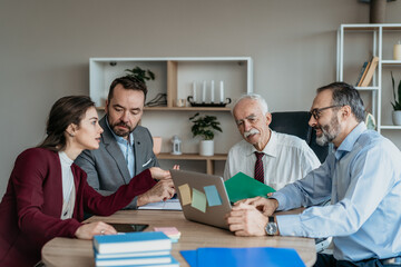 Fototapeta premium Multi-Generational Business Team Showing Work to Senior Executive in Modern Office – Mixed Generations