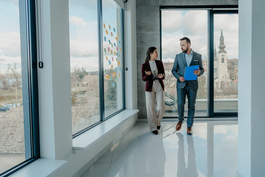 Middle-Aged Man and Young Woman Focused Working in Modern Office with Sticky Notes &ndash; HR Concept