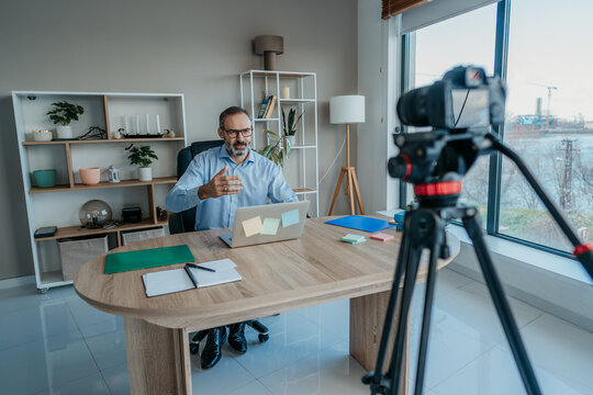 Middle Aged Businessman Recording Vlog in Office With Camera