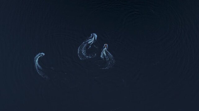 Overhead view of three jet skis on lake water, Northern Europe