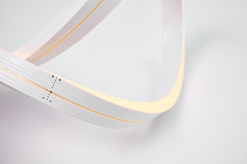 Flexible warm white led tape glowing on white background.
