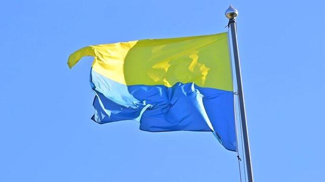 Ukrainian National Flag Waving in Wind Against Clear Blue Sky, Summer Day Scene