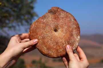 Hand holding Moroccan round bread. Cuisine of Morocco.