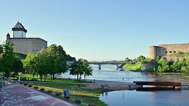 Border Bridge over Narva River Connecting Estonia and Russia. Historic Castles Facing Each Other Across the Narva River During Daytime.