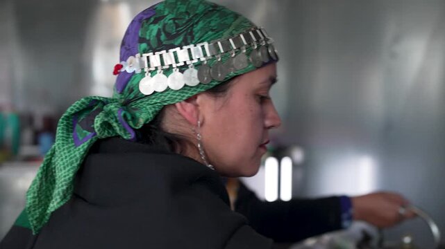 Indigenous women in traditional clothing cooking in a kitchen, preparing and serving a sopaipilla