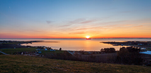 Obraz premium Norwegischer Sonnenuntergang über Bucht Inseln und Küstendor