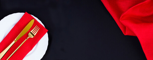 Setting the table with red napkin on a black background. Top view. Copy space.