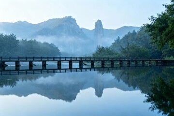 Obraz premium Bridge over calm water with mountain backdrop