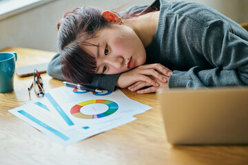 A young woman slumped at her desk