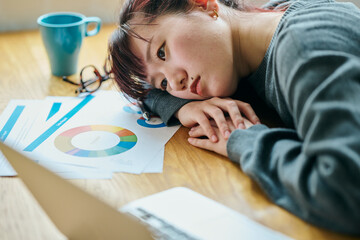 A young woman slumped at her desk
