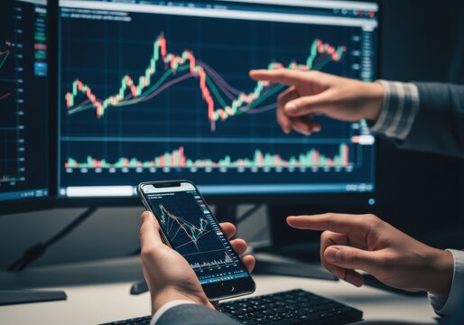 Two people analyzing stock market data a computer monitor and smartphone in an office setting - Powered by Adobe