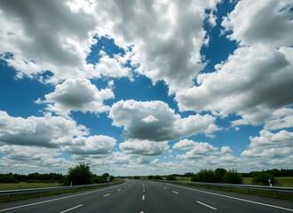 Fototapeta premium Empty highway road with metal guardrails under blue sky with white clouds
