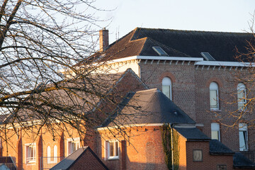 Traditional red brick architecture in warm sunset light viewed through bare winter trees