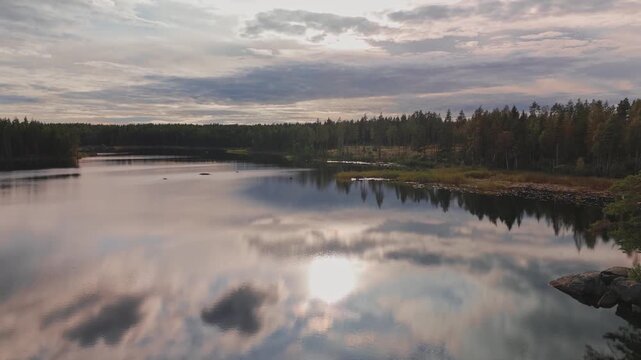 Calm lake with sky and clouds reflected on water surface, Northern Europe