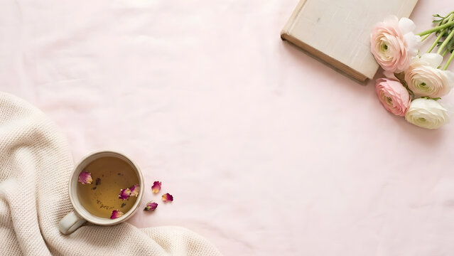 Self love Valentine Cozy morning setup with tea, flowers, and book on soft pink background with copy space