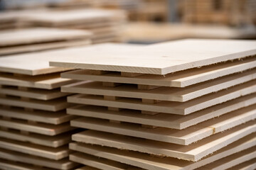 Wooden planks stacked neatly in a workshop showcasing the materials used for construction