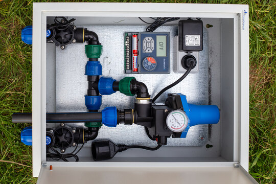 Installation of an automated drip irrigation system for a garden in a metal box.
