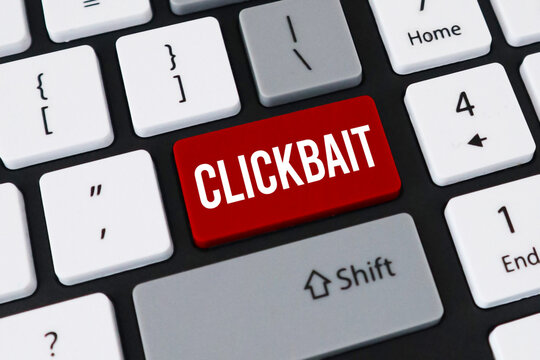 Red clickbait button on computer keyboard. Concept of misleading headlines, internet deception and web traffic.