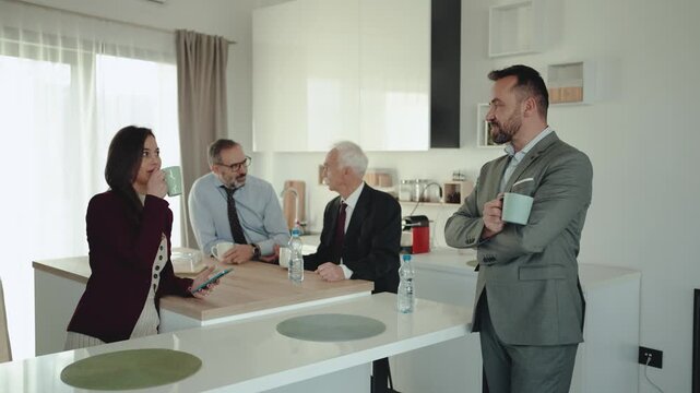 Multi-Generational Business Team Having Coffee and Chat in Office Kitchen