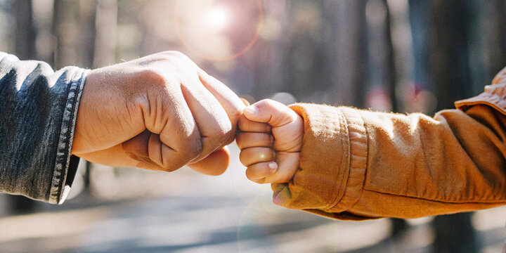 Lifestyle background. Hands of adults and children clenching fists collide with the ideas of trust and intergenerational relationships.