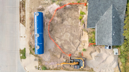 Aerial view of a construction site installing a new underground storage tank at a gas station.