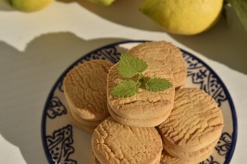 Round shortbread cookies with mint leaf on decorative plate © Gulnaz