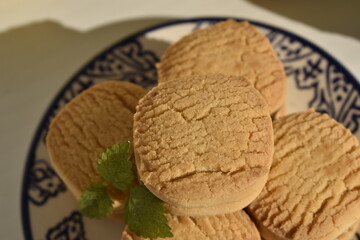Round shortbread cookies with mint leaf on decorative plate © Gulnaz