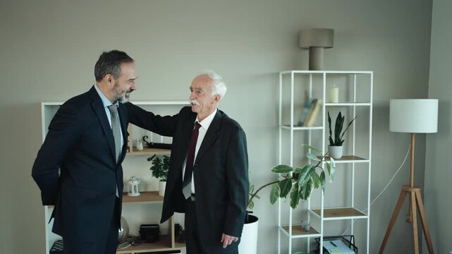 Father and Son Businessmen Discussing Succession in Modern Office &ndash; Senior and Middle Aged