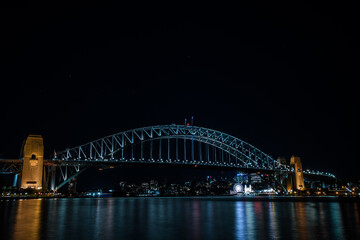 Fototapeta premium Paysage urbain au crépuscule avec une vue du port de Sydney et son pont illuminé
