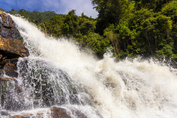 Powerful Bomburu Ella Waterfall Cascading Over Dark Rock in Lush Tropical Forest, Sri Lanka