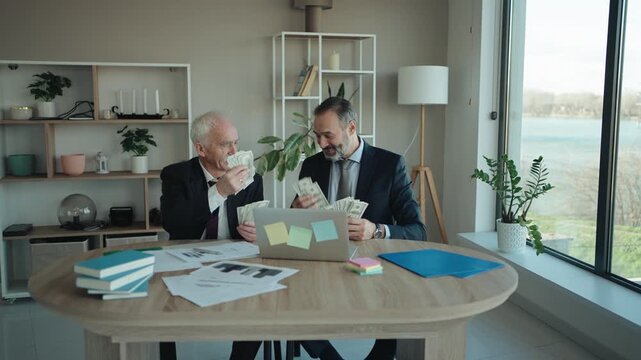 Senior and Middle Aged Businessmen Counting Money and Celebrating in Modern Office &ndash; Father and Son