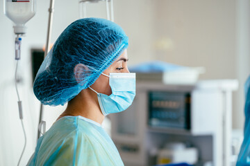 Side view portrait of focused female surgeon during medical procedure